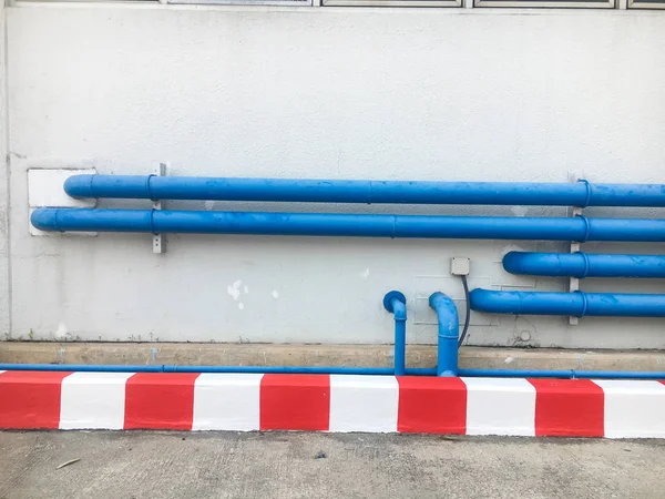 front shot of blue pipes on white wall