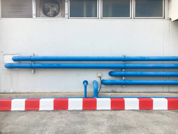 front shot of blue pipes on white wall