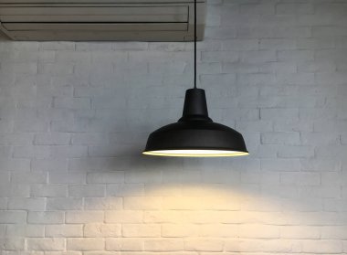 Tavan asılı lamba siyah fikstür ve beyaz tuğla duvar iç dekorasyon tasarımı için arka plan var.