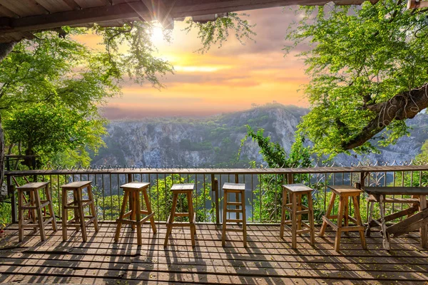 Relax corner with wooden chairs and mountain view on sunrise.