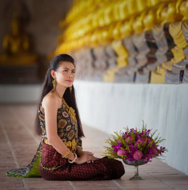 Taylandlı güzel bir kadın, Tayland 'ın Ayutthaya ilinde eski bir tapınakta Buda için dua edecek pembe nilüferleri var.. 
