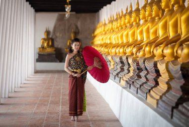 Taylandlı güzel bir kadın, Tayland 'ın Ayutthaya ilinde eski bir tapınakta Buda için dua edecek pembe nilüferleri var.. 