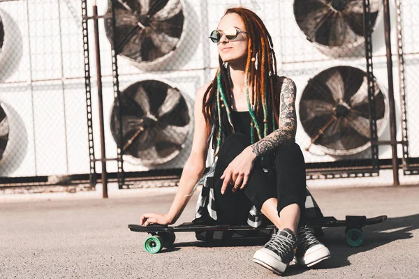 Young girl with tattoo and dreadlocks on urban industrial background — Stock Photo, Image