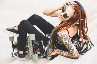 dövme ve belgili tanımlık merdiven üstünde otururken müzik dreadlocks ile genç kız