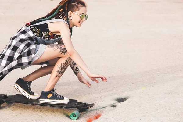 Jovem com passeios de tatuagem em um longboard — Fotografia de Stock