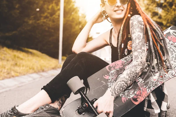 UFA, RÚSSIA - 12 de setembro de 2018 Foto editorial de uma jovem com tatuagens e dreadlocks sentada no parque — Fotografia de Stock