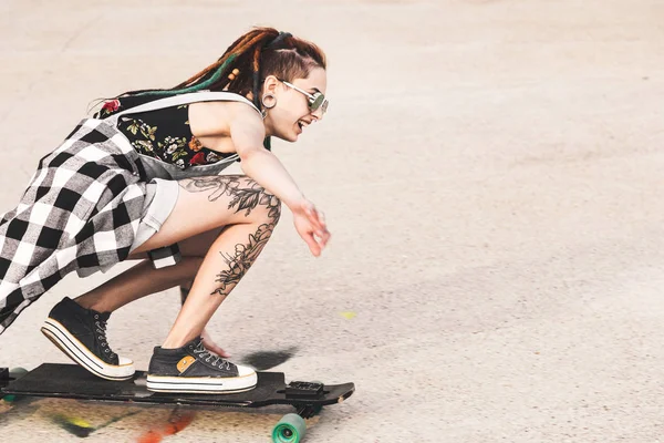 Jovem com passeios de tatuagem em um longboard — Fotografia de Stock