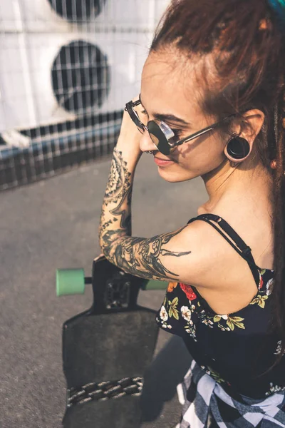 Chica joven con tatuaje y rastas en el fondo industrial urbano —  Fotos de Stock