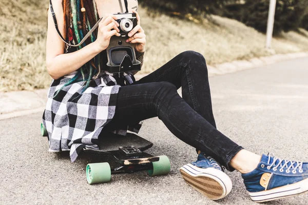 Chica joven con tatuajes y rastas fotografías cámara vintage en el parque —  Fotos de Stock