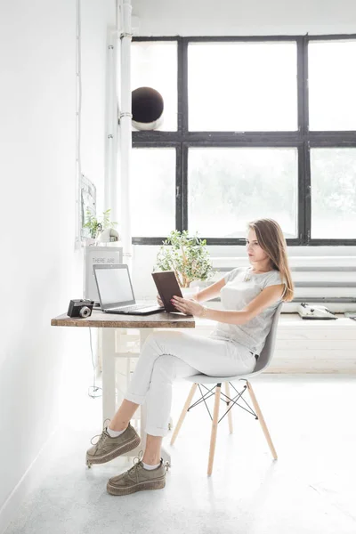 Jonge zakenvrouw thuis werken en lezen van een boek. Creatieve Scandinavische stijl werkruimte — Stockfoto