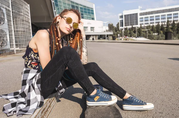 Chica joven con tatuaje y rastas en el fondo industrial urbano —  Fotos de Stock