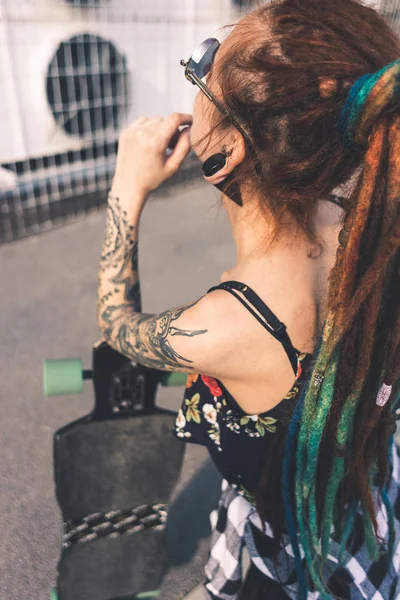 Young girl with tattoo and dreadlocks on urban industrial background — Stock Photo, Image