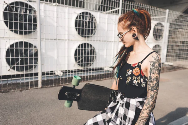 Chica joven con tatuaje y rastas en el fondo industrial urbano — Foto de Stock