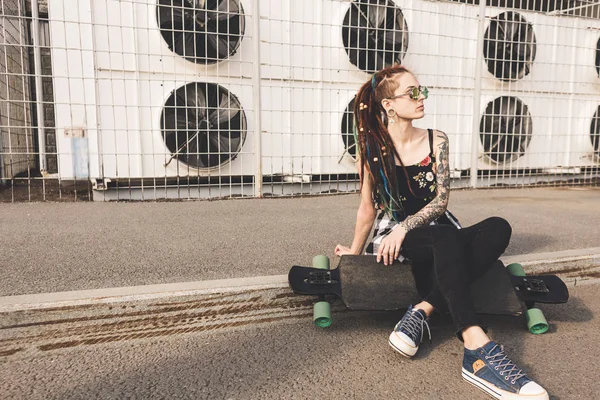 Junges Mädchen mit Tätowierung und Dreadlocks auf industriellem Hintergrund — Stockfoto