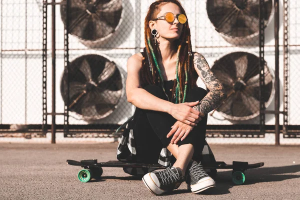 Chica joven con tatuaje y rastas en el fondo industrial urbano —  Fotos de Stock