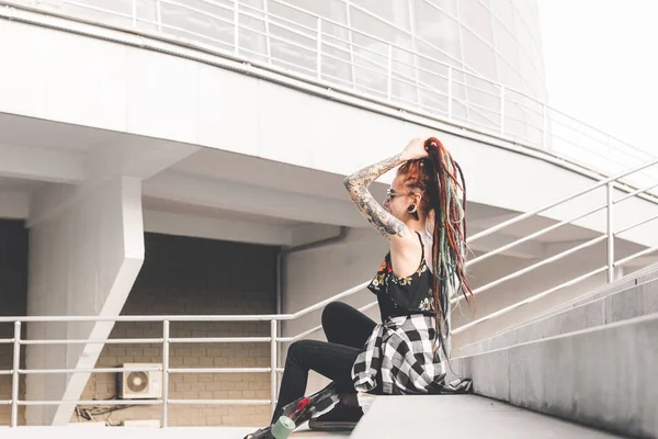 Chica joven con tatuaje y rastas sentado en las escaleras — Foto de Stock