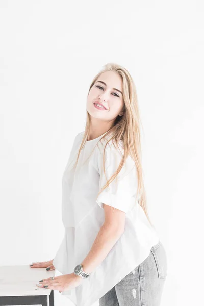 Портрет молодой стильной блондинки, позирующей перед камерой на белом фоне — стоковое фото