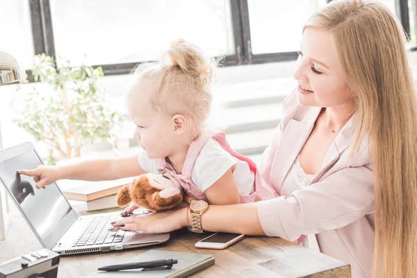 Young business woman working at home behind the laptop with a little child. Creative Scandinavian style workspace. Work on maternity leave — Stock Photo, Image