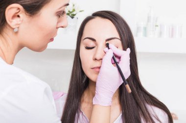 Kaşları güzellik salonu içinde güzel genç kadın için kalıcı makyaj