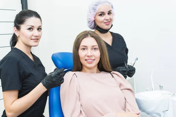 Clínica dentária. Recepção, exame do paciente. Cuidado com os dentes. Jovem é submetida a um exame odontológico por um dentista — Fotografia de Stock