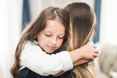 Güzel genç kadın ve sevimli küçük kızını sarılma ve gülümseyen