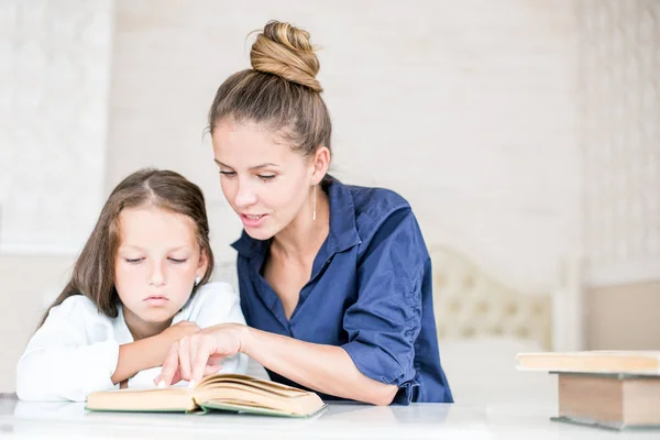 Familia feliz madre e hija leyeron un libro por la noche en casa. el concepto de confort familiar y relaciones familiares — Foto de Stock