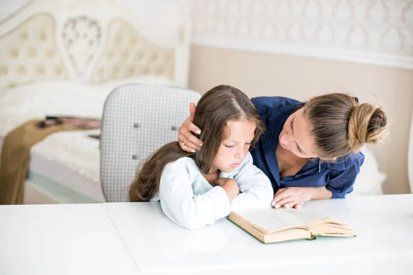 Familia feliz madre e hija leyeron un libro por la noche en casa. el concepto de confort familiar y relaciones familiares — Foto de Stock
