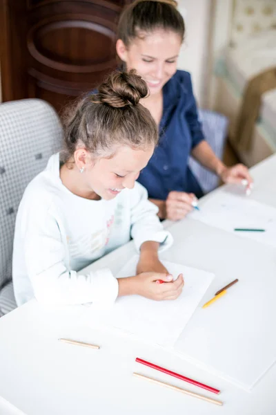 Gelukkige familie. Moeder en dochter samen verf en tekenen. Volwassen vrouw helpt het meisje kind — Stockfoto