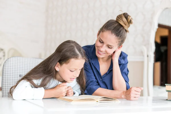 Familia feliz madre e hija leyeron un libro por la noche en casa. el concepto de confort familiar y relaciones familiares — Foto de Stock