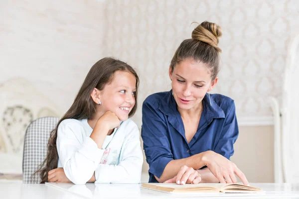 Familia feliz madre e hija leyeron un libro por la noche en casa. el concepto de confort familiar y relaciones familiares — Foto de Stock