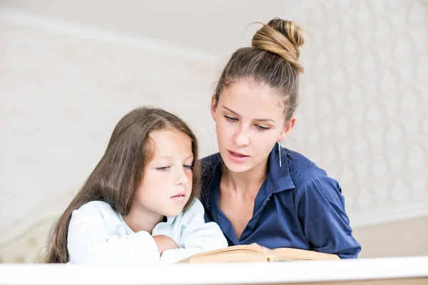 Familia feliz madre e hija leyeron un libro por la noche en casa. el concepto de confort familiar y relaciones familiares — Foto de Stock