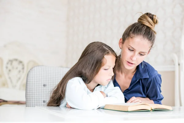 Familia feliz madre e hija leyeron un libro por la noche en casa. el concepto de confort familiar y relaciones familiares — Foto de Stock