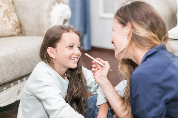 Feliz familia amorosa. Madre e hija están haciendo el pelo, manicuras, hacer su maquillaje y divertirse — Foto de Stock