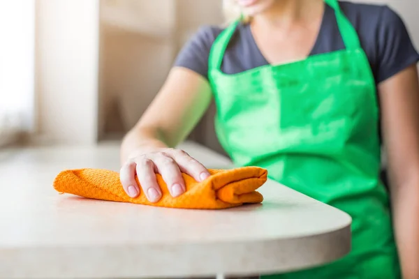 A takarítási szolgáltatást. egy fiatal nő, egy kötény darabos por egy ronggyal — Stock Fotó