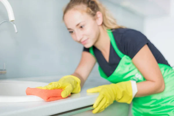 Zbliżenie kobieta ręce w rękawiczkach gumowych żółty czyszczenia panelu kuchenka w domu kuchnia. Koncepcja domu, sprzątanie. sprzątanie — Zdjęcie stockowe