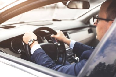 prestijli bir araba bir işadamı bir cep telefonu elinde tutuyor. Aceleci hayat