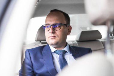 Genç iş adamı ile kodlanmış bir salon pahalı bir arabada arka koltuğunda, bir toplantı için gittiği...