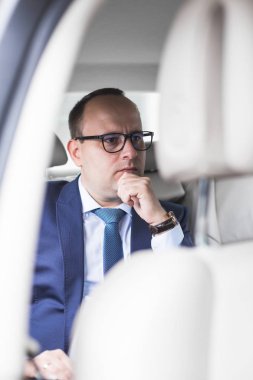 Genç iş adamı ile kodlanmış bir salon pahalı bir arabada arka koltuğunda, bir toplantı için gittiği...