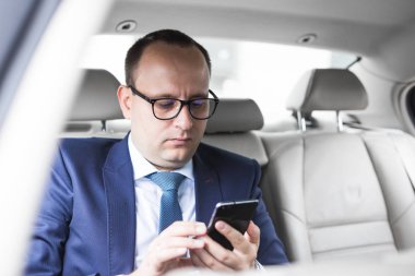 elit bir araba, konuşmalar ve iş toplantıları arka koltukta oturan telefonda konuşurken genç başarılı iş adamı