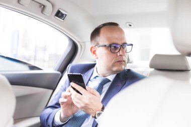 elit bir araba, konuşmalar ve iş toplantıları arka koltukta oturan telefonda konuşurken genç başarılı iş adamı