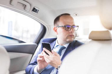 elit bir araba, konuşmalar ve iş toplantıları arka koltukta oturan telefonda konuşurken genç başarılı iş adamı