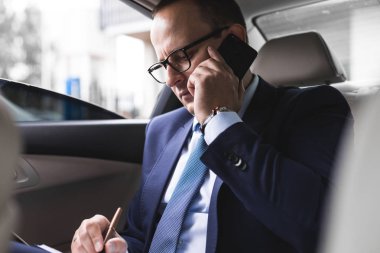 elit bir araba, konuşmalar ve iş toplantıları arka koltukta oturan telefonda konuşurken genç başarılı iş adamı