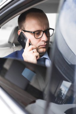 elit bir araba, konuşmalar ve iş toplantıları arka koltukta oturan telefonda konuşurken genç başarılı iş adamı