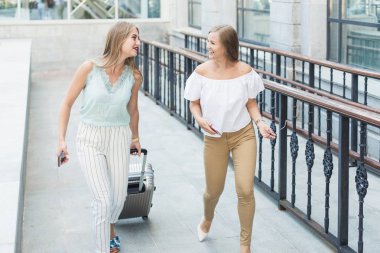 iki güzel sarışın genç kız bavul pahalı bir otelin arka plan üzerinde. Bir turist tatil Bagaj ile dostları