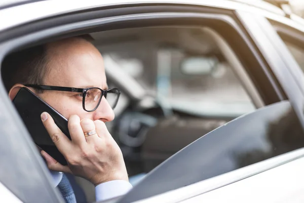 Młodym biznesmenem rozmawia przez telefon, siedzący na tylnym siedzeniu elity samochodów, rozmów i spotkań biznesowych — Zdjęcie stockowe