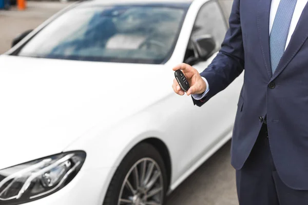 Man håller bilnycklar med bil på bakgrund — Stockfoto