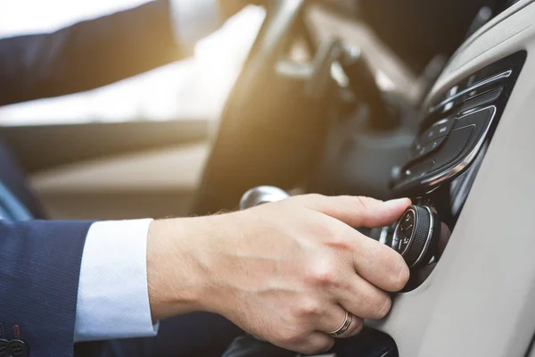 Mannen trycker på knapparna i bilen i ljusa mozannom salongen. Justering av VVS — Stockfoto