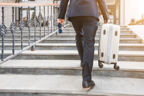 Hombre sosteniendo la maleta. hombre de negocios con equipaje viaja, va a una reunión de negocios — Foto de Stock