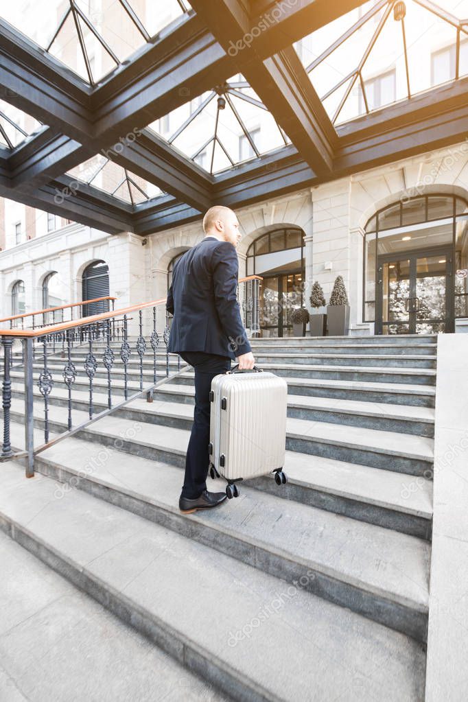 Man holding suitcase. businessman with luggage travels, goes to a business meeting