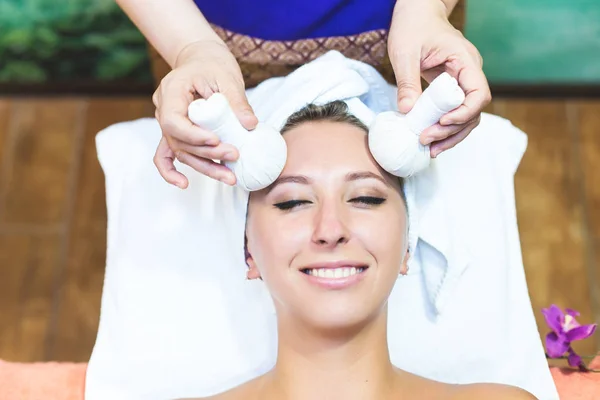 beautiful girl enjoys face massage in spa salon. Procedures for beauty and rejuvenation. Thai massage